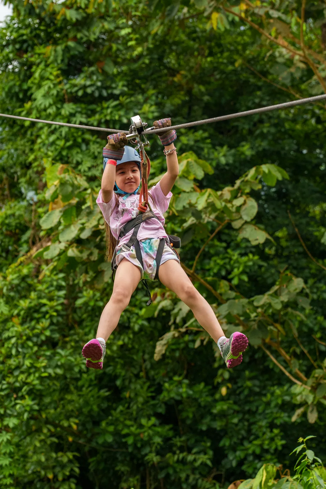 A young traveller riding a zipline over the rainforest canopy